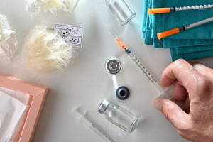 Detail of nurse holding syringe on a white hospital table, a Health & Medical Photo by Davizro's Market