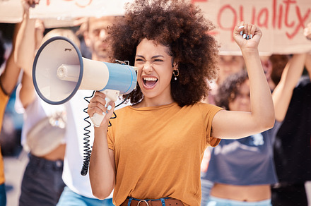 Megaphone, equality or women rights protest for global change, gender equality or angry black woman fight for support. Crowd poster banner, city speech or human rights rally by social justice warrior, a Photo by Peopleimages.com