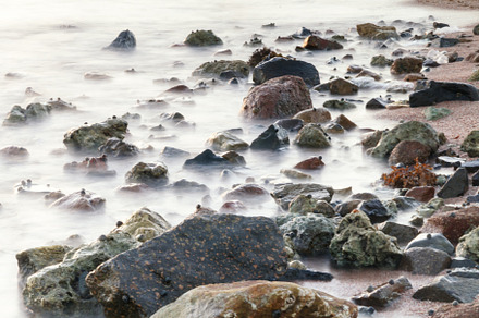long exposure of sea and rocks and stones, teal tone, a Nature Photo by TanaCh