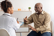 Black patient talking to doctor during appointment, a Photo by Prostock-Studio (Thumbnail 1 of 2)