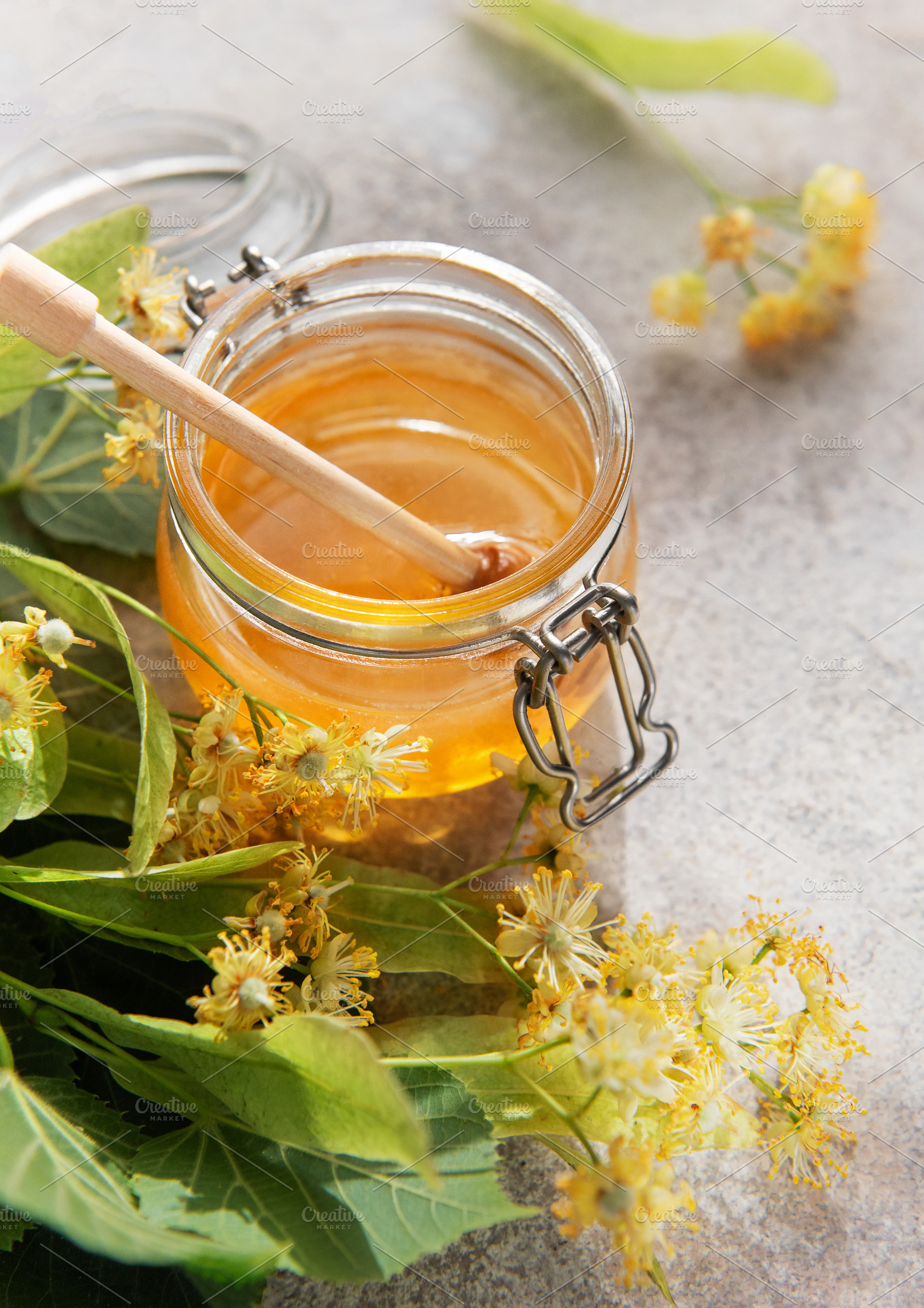 Honey jar with linden blossoms and wooden dipper, a Food & Drink Photo by Olena Rudo