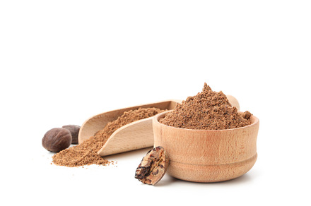 Scoop and bowl with nutmeg powder and nutmegs isolated on white, a Food & Drink Photo by AtlasStudio PRO