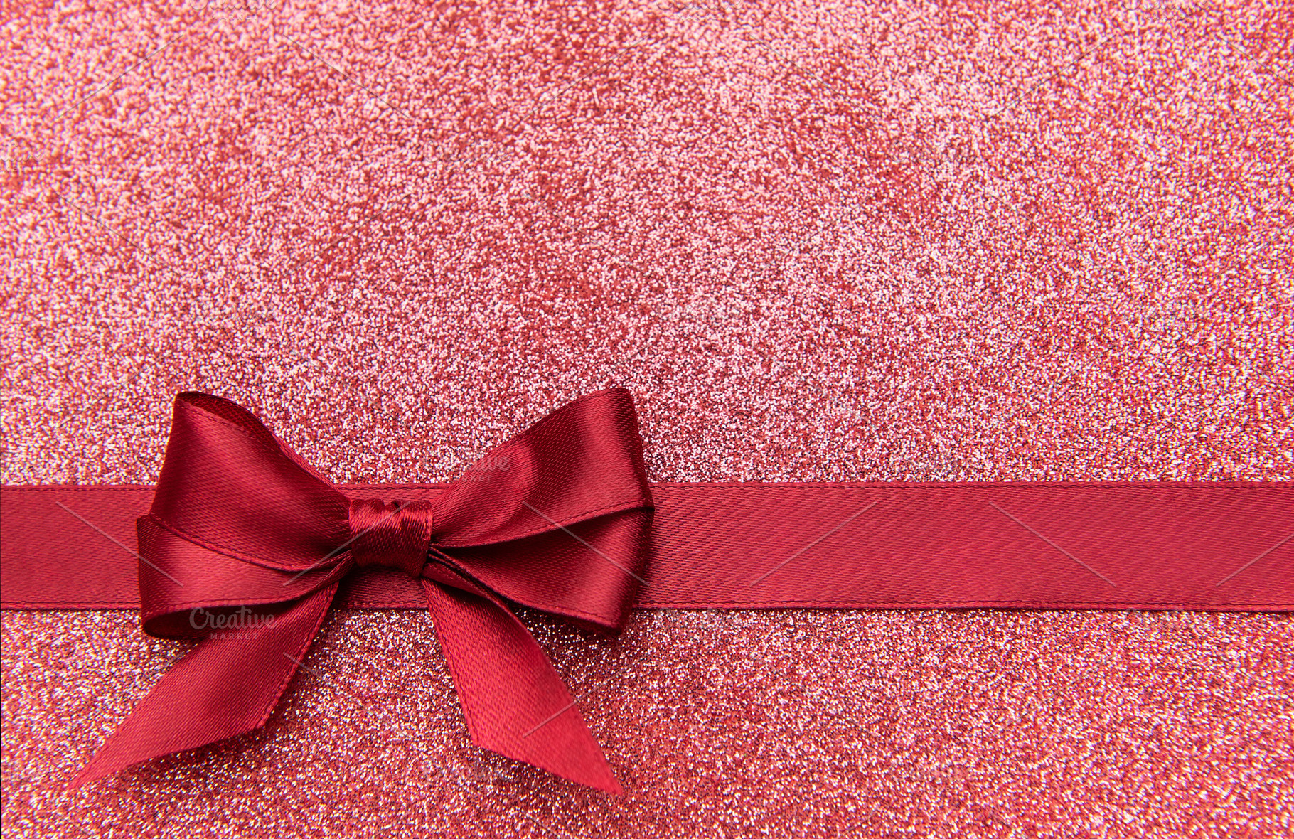 Red glitter background with decorative ribbon bow, a Holiday Photo by Olena Rudo