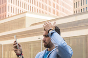 Handsome young man smiling when he is using his mobile phone, a Person Photo by RF Images (Thumbnail 1 of 2)