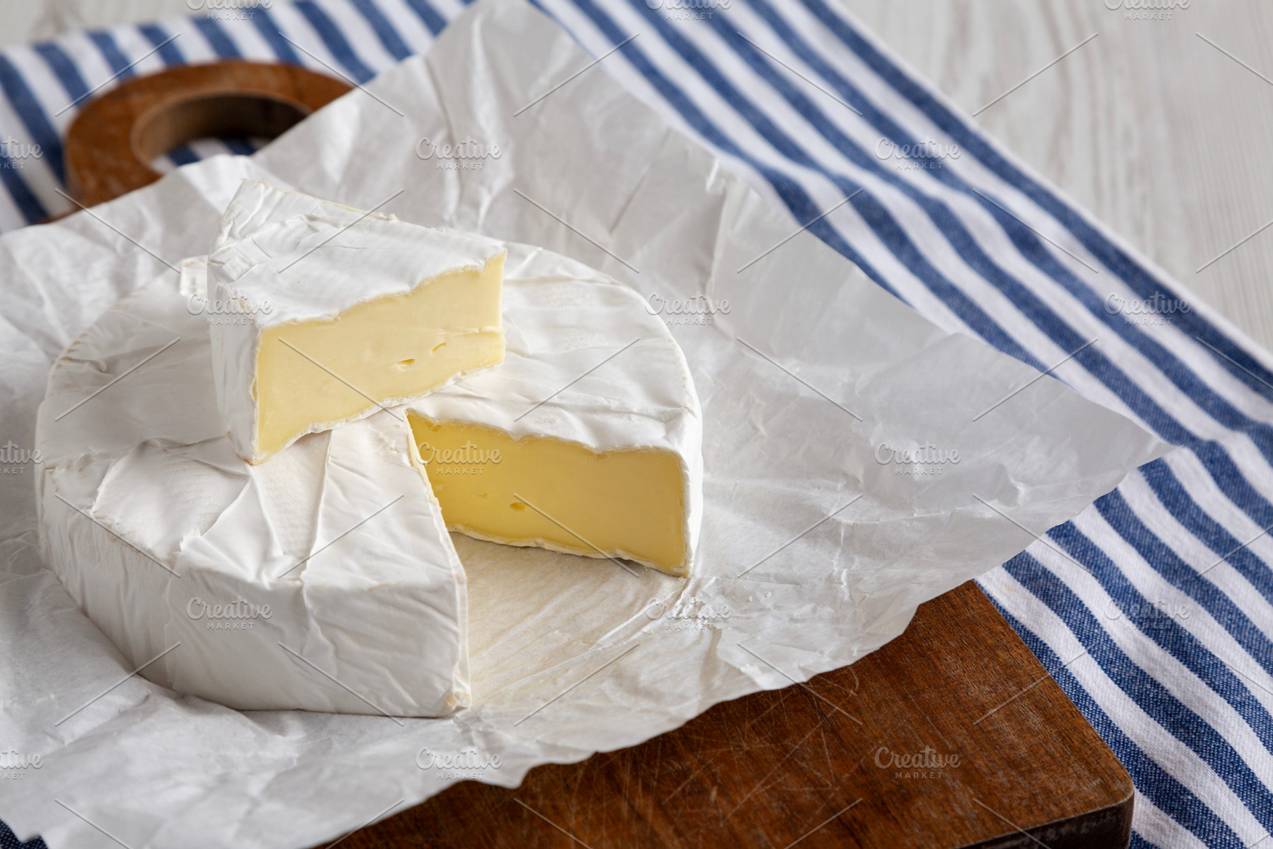 Homemade White Brie Cheese on a Wooden Board, side view., a Food & Drink Photo by LiudmylaChuhunova