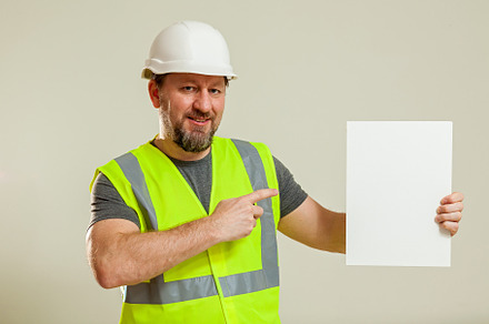 worker in a vest and white helmet, a Person Photo by Photostock