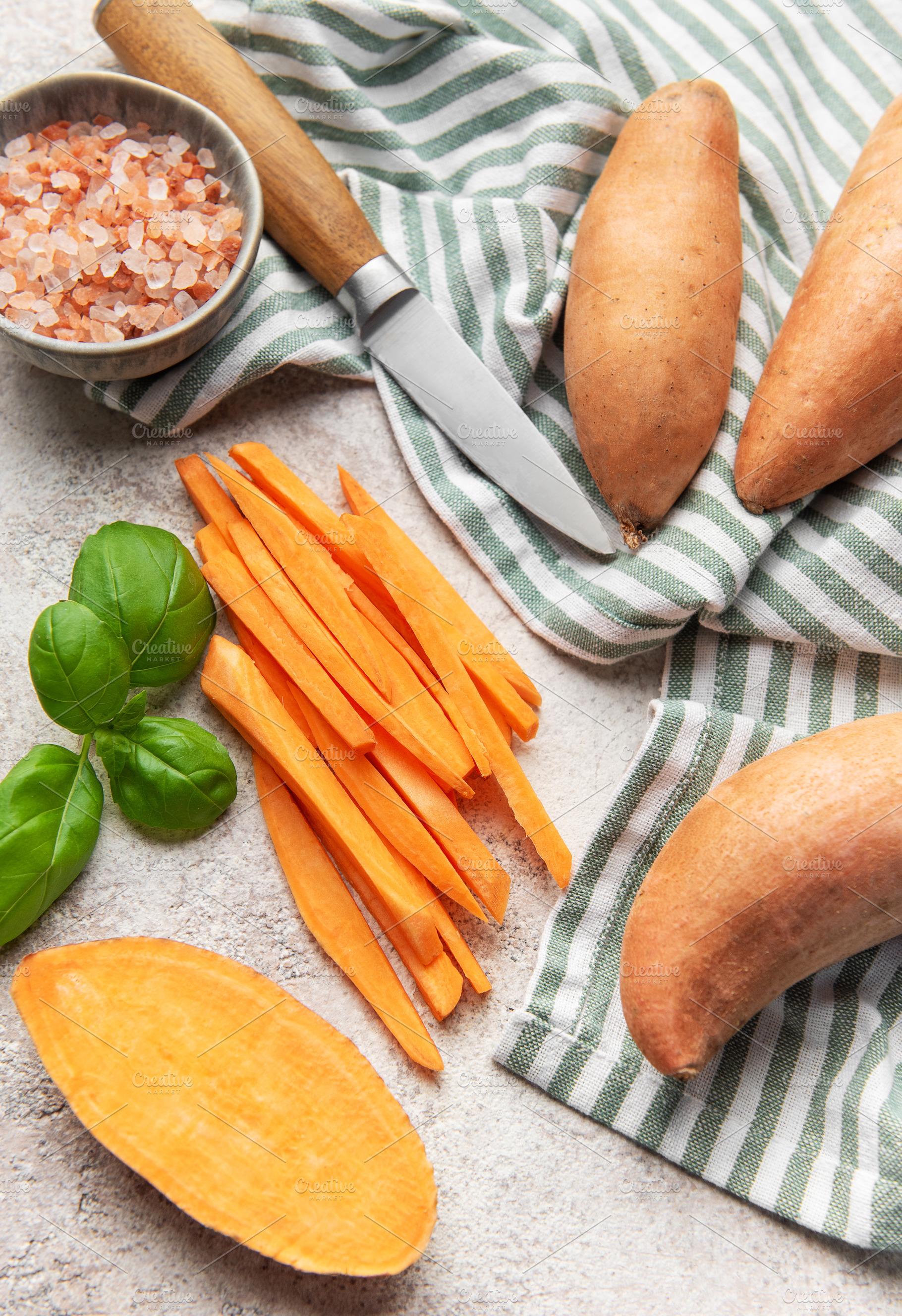 Preparing sweet potato fries with salt, basil, and a knife, a Food & Drink Photo by Olena Rudo