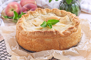 Freshly baked old fashioned deep dish peach pie cooling on baking rack, horizon, a Food & Drink Photo by iuliia_n