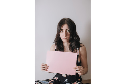Sad young woman holding a blank, a Person Photo by zheckasmk