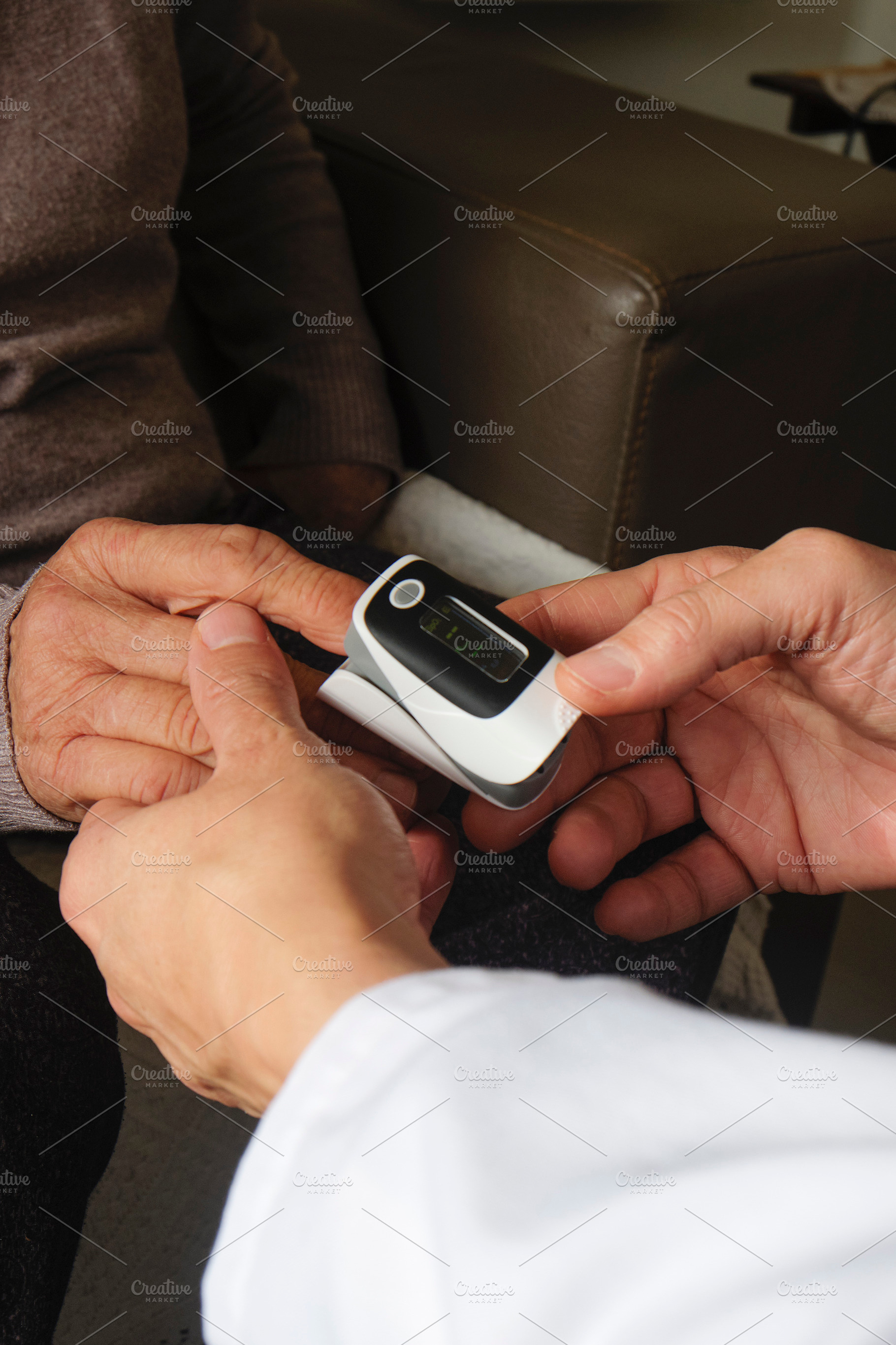 a doctor assessing an elderly woman with oximeter, a Photo by Nito
