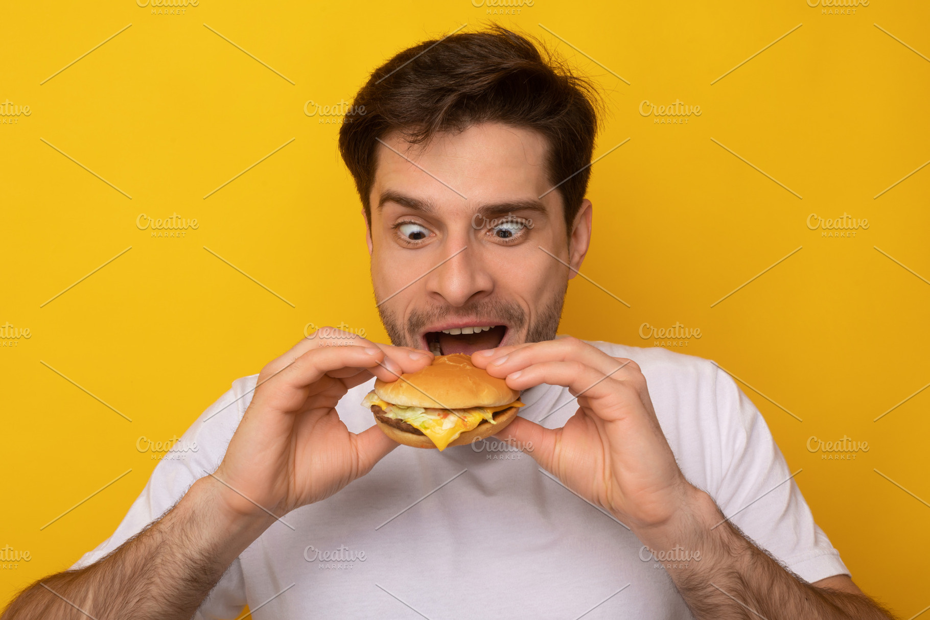 Funny Guy Holding Burger Biting Sandwich At Studio, a Photo by Prostock-Studio