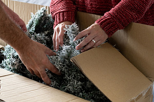 Young couple unpacking Artificial Christmas Tree from Storage Box at home, a Holiday Photo by etorres69