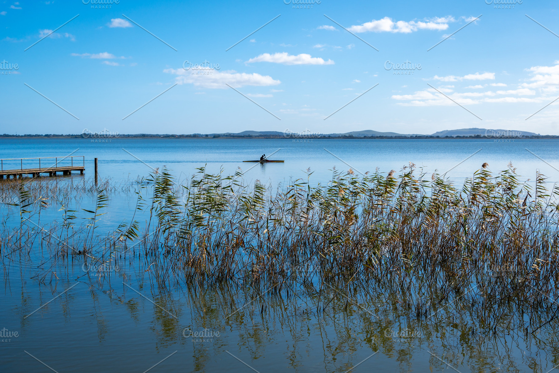 Kayaker paddling near wooden pier on Lake Colac, Victoria, Austr, a Nature Photo by GoodGoods