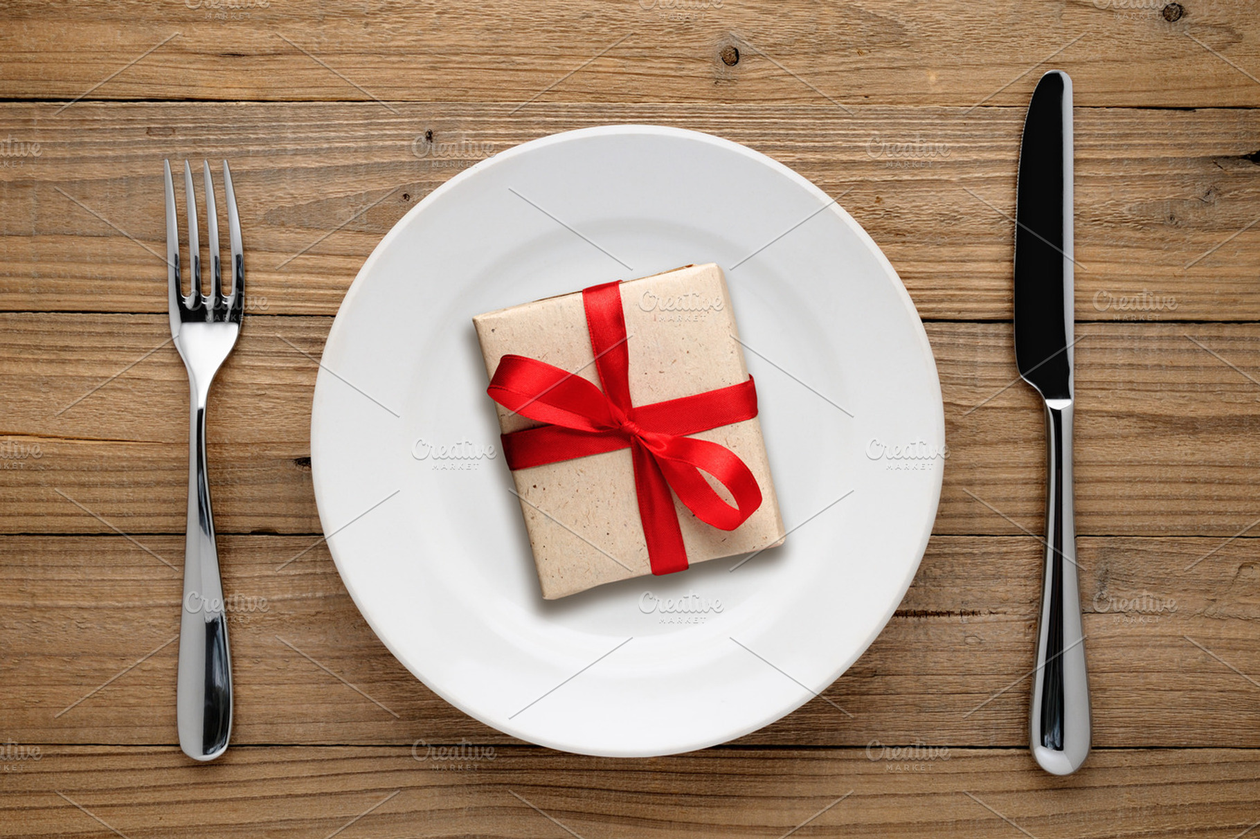 Gift box with red bow on plate