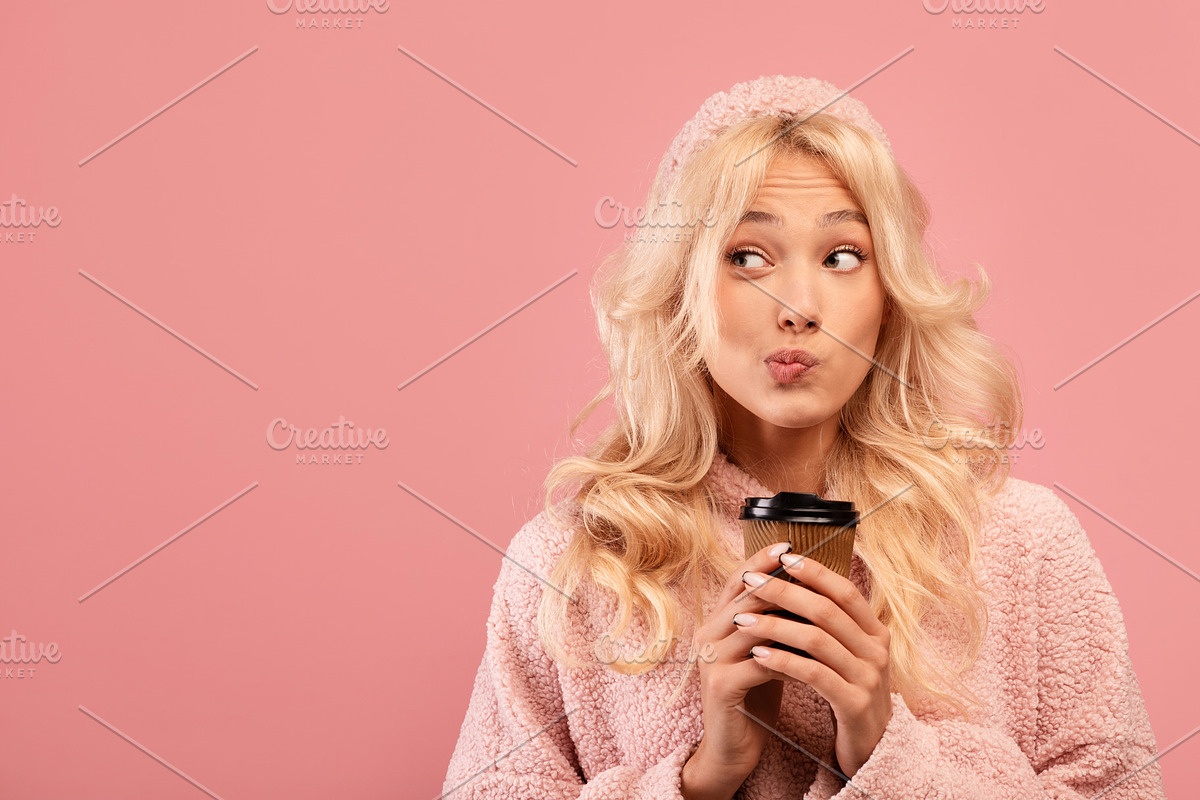 Dreamy young lady holding takeaway coffee and looking aside at empty space on p, a Photo by Prostock-Studio (Photo 1 of 2)