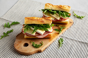 Homemade French Ham and Brie Baguette with Arugula Greens, side, a Food & Drink Photo by LiudmylaChuhunova