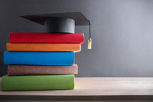 Graduation concept with mortarboard on stack of books on table, a School & Education Photo by Davizro's Market