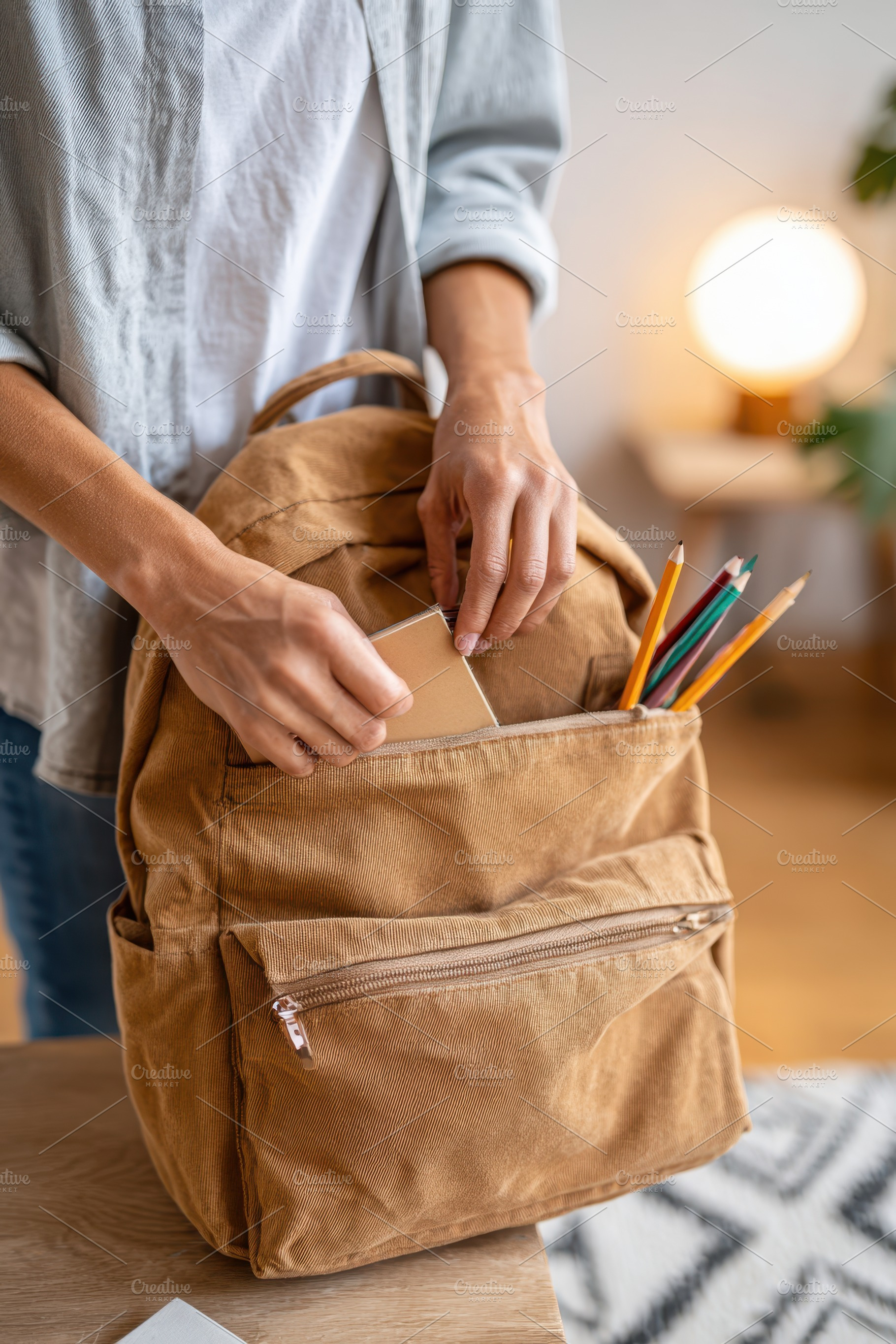Packing notebook into tan backpack, a Holiday Photo by AlyaAnd