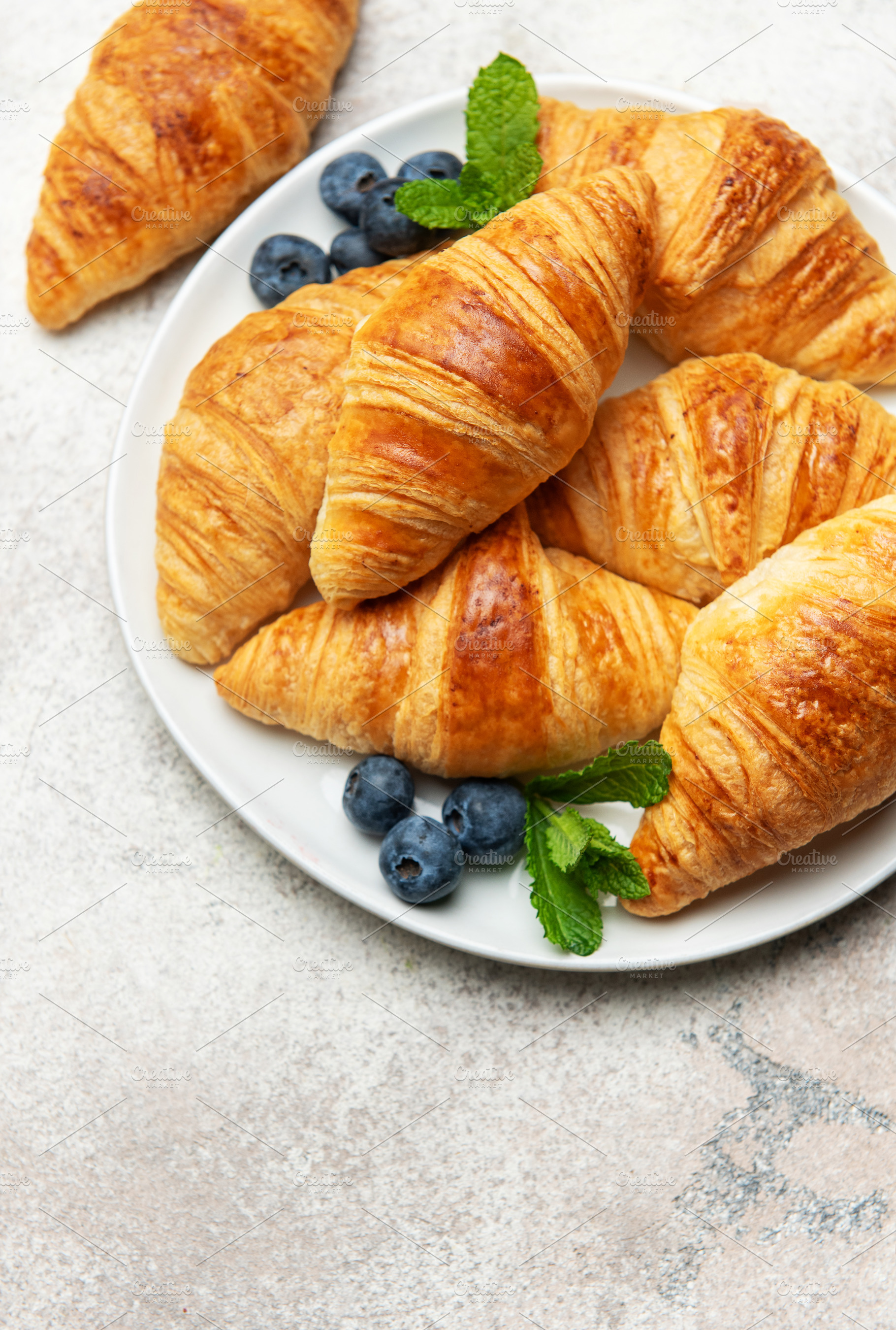 Freshly baked croissants with blueberries and mint on white plat, a Food & Drink Photo by Olena Rudo