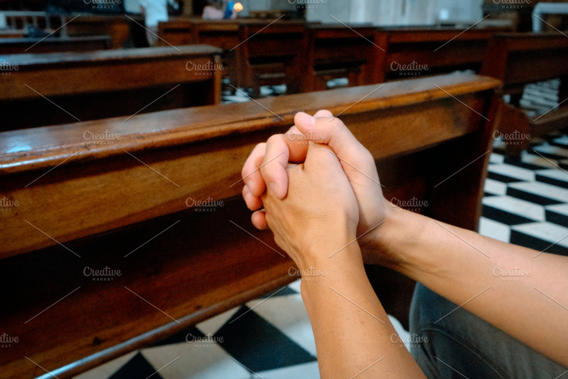 side view of a man with interlaced fingers in prayer, a Photo by Nito