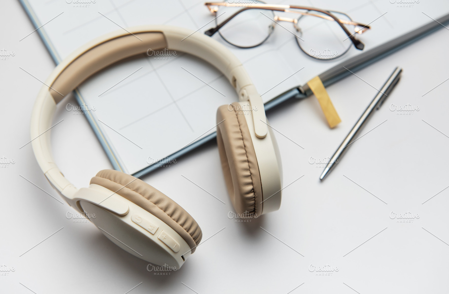 Wireless headphones, planner, eyeglasses and pen lying on white, a Business Photo by Olena Rudo