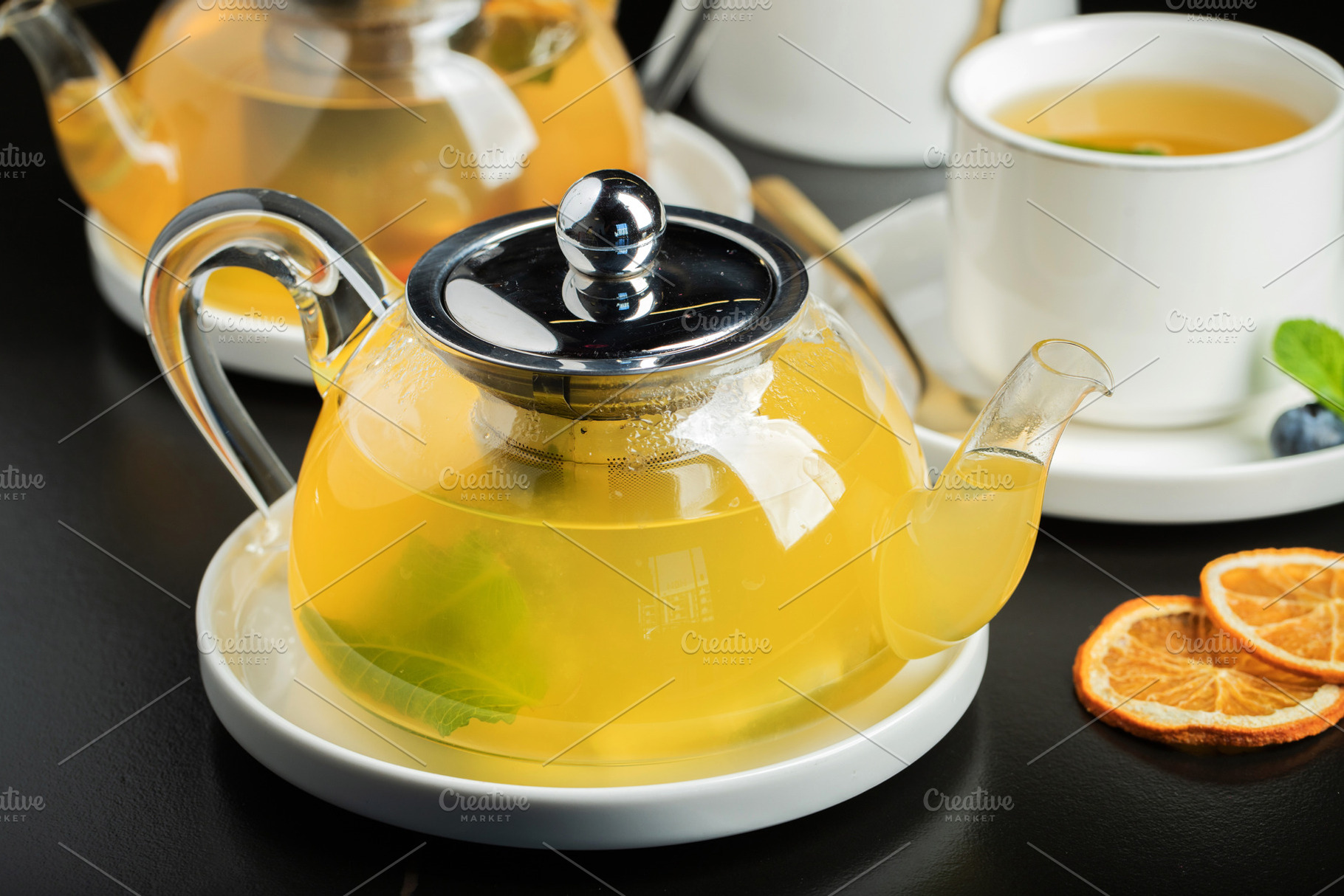 Fruit tea with mango and mint in a glass teapot on the table, a Food & Drink Photo by Budarinphoto