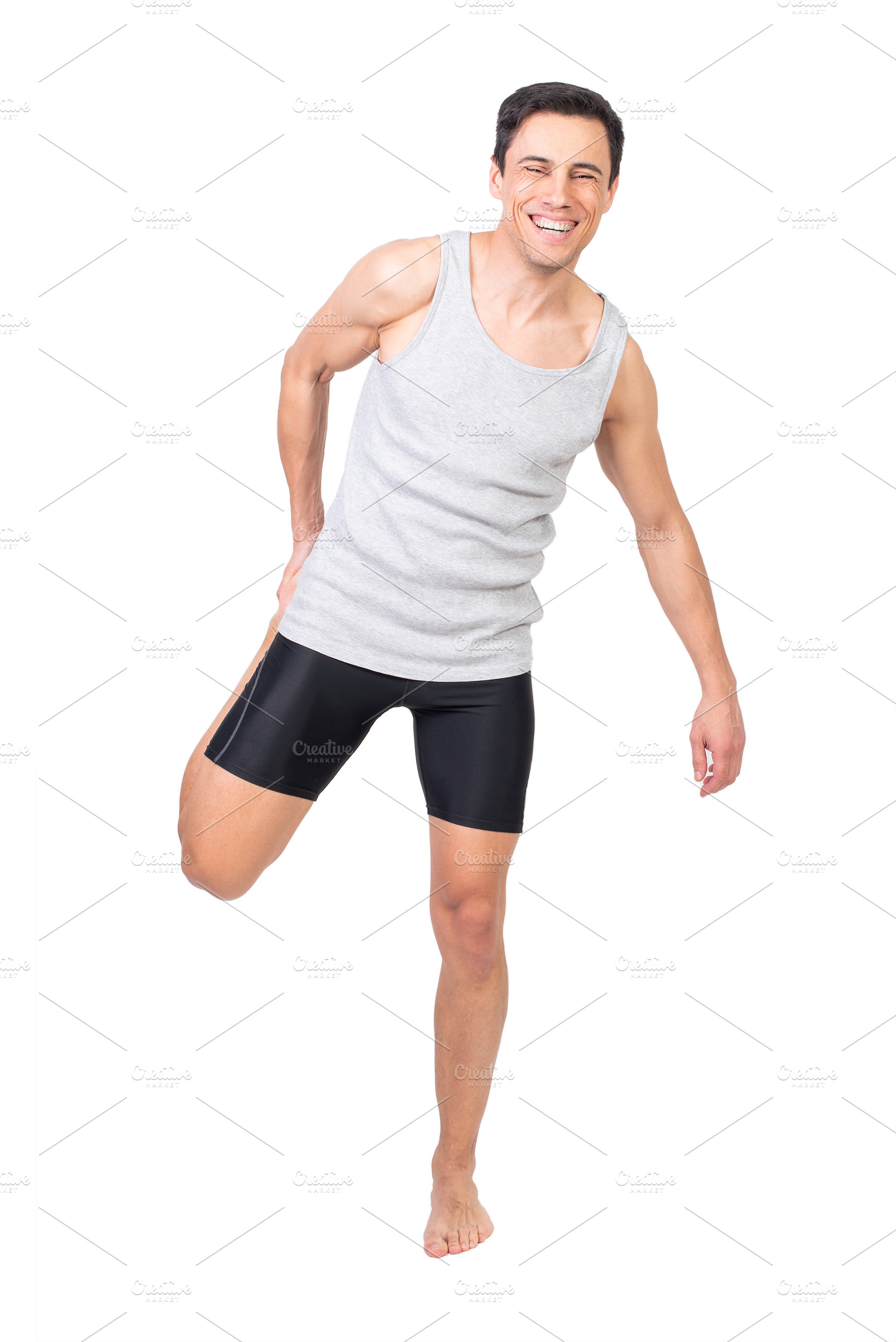 Cheerful sportsman stretching quadriceps muscle, a Sports & Recreation Photo by Iván Moreno STOCK PHOTO