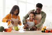 Joyful Black Family Making Fresh Vegetable Salad In Modern Kitchen, a Photo by Prostock-Studio (Thumbnail 1 of 2)