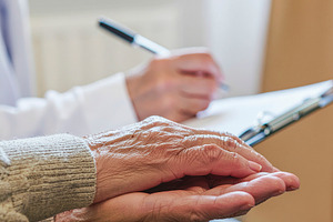 Geriatric consultation hands and notes closeup, a Photo by DanFLCreativo