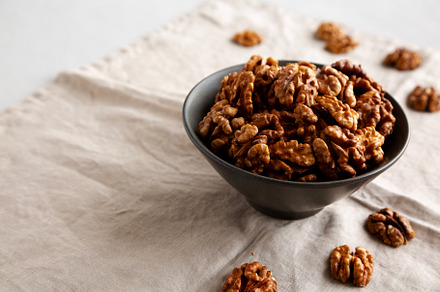 Raw Walnut Halfs in a Bowl, side view. Copy space.