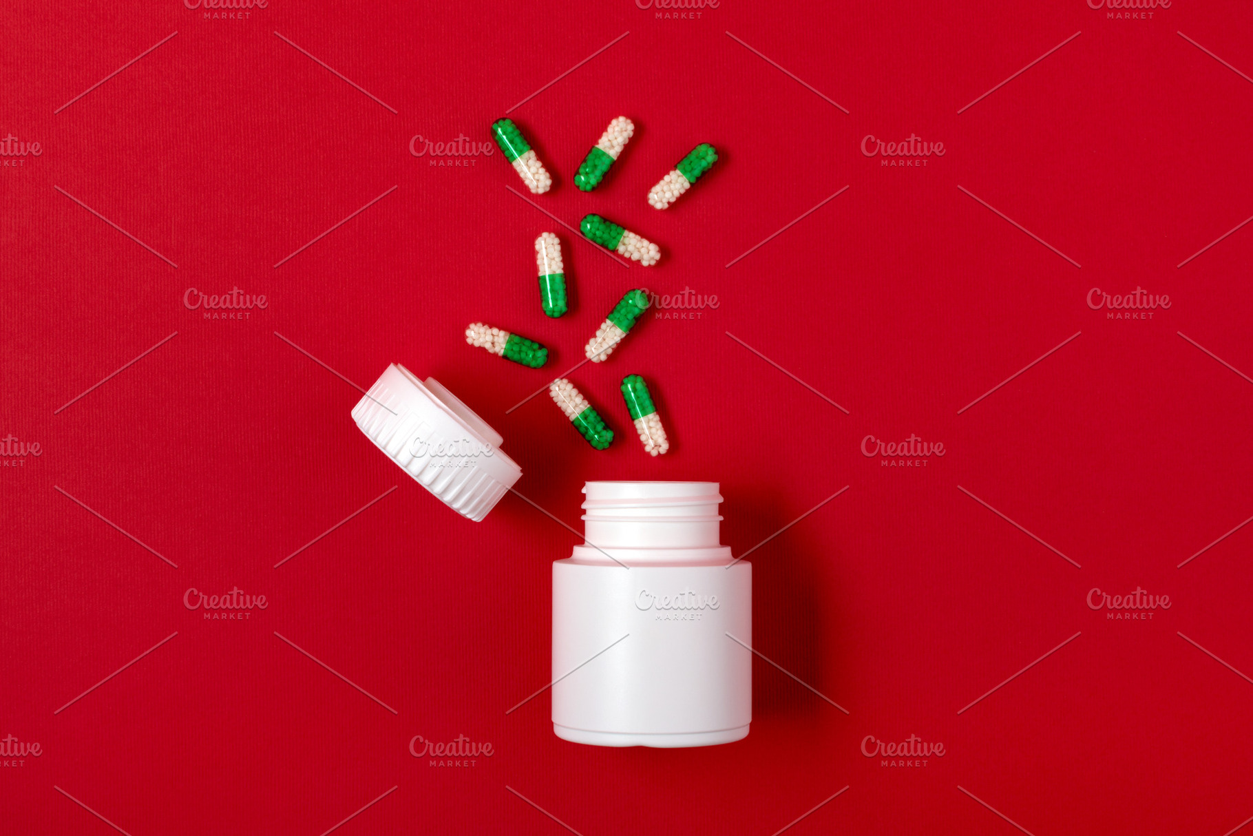 White plastic pill bottle with scattered green and white capsules on a vibrant, a Health & Medical Photo by Ales Munt