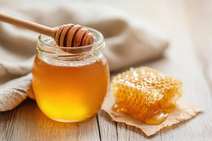 Honey and honeycomb displayed on a wooden table with soft natural light in the, a Food & Drink Photo by AlyaAnd