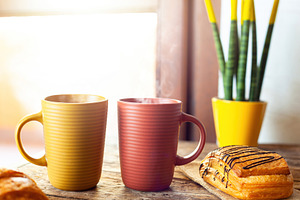 Steaming mugs and pastries enjoying morning sunlight near window, a Food & Drink Photo by Antonio Gravante Market