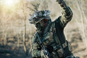 Soldier wearing camouflage giving orders during combat training in the forest, a Sports & Recreation Photo by Antonio Gravante Market