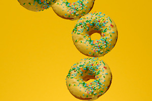 Yellow glazed donuts, each decorated with multi colored sprinkle, a Food & Drink Photo by ndanko