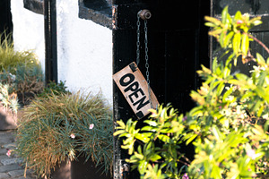 Wooden open sign on a café containing open, sign, and door