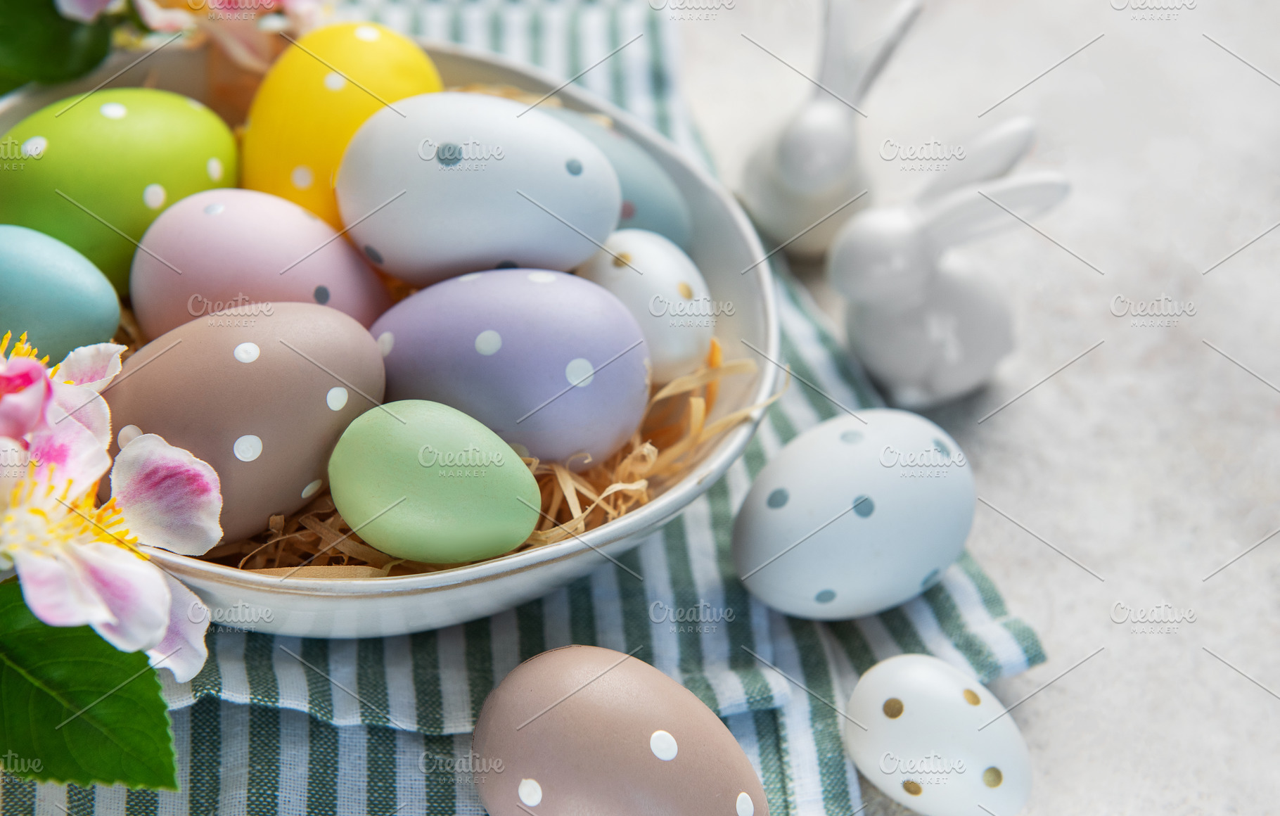 Pastel easter eggs in bowl with bunnies decoration, a Holiday Photo by Olena Rudo