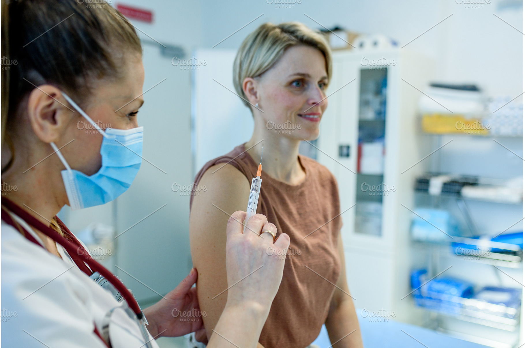 Doctor administering vaccine to, a Health & Medical Photo by HalfPoint