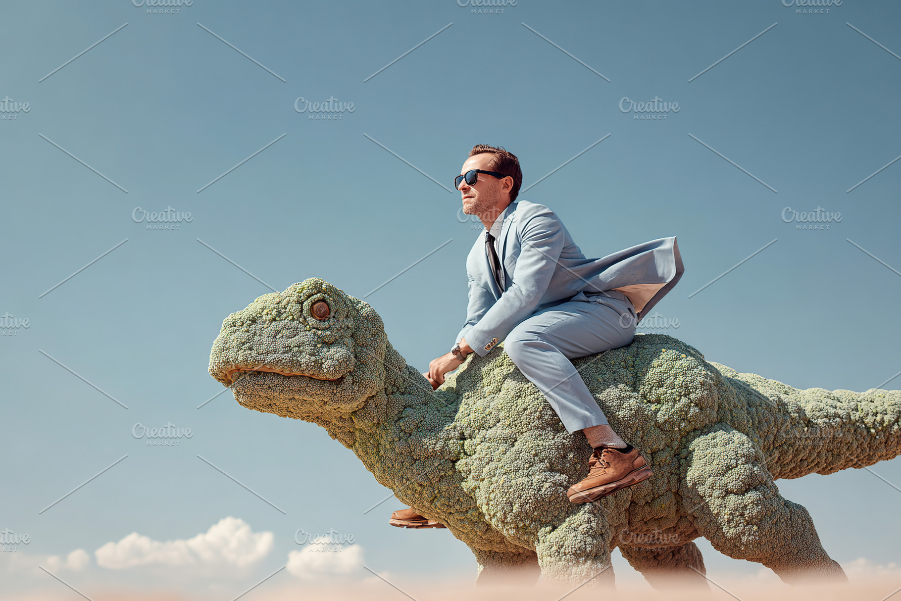 Man in a suit rides a dinosaur sculpture under a clear blue sky, a Photo by AlyaAnd
