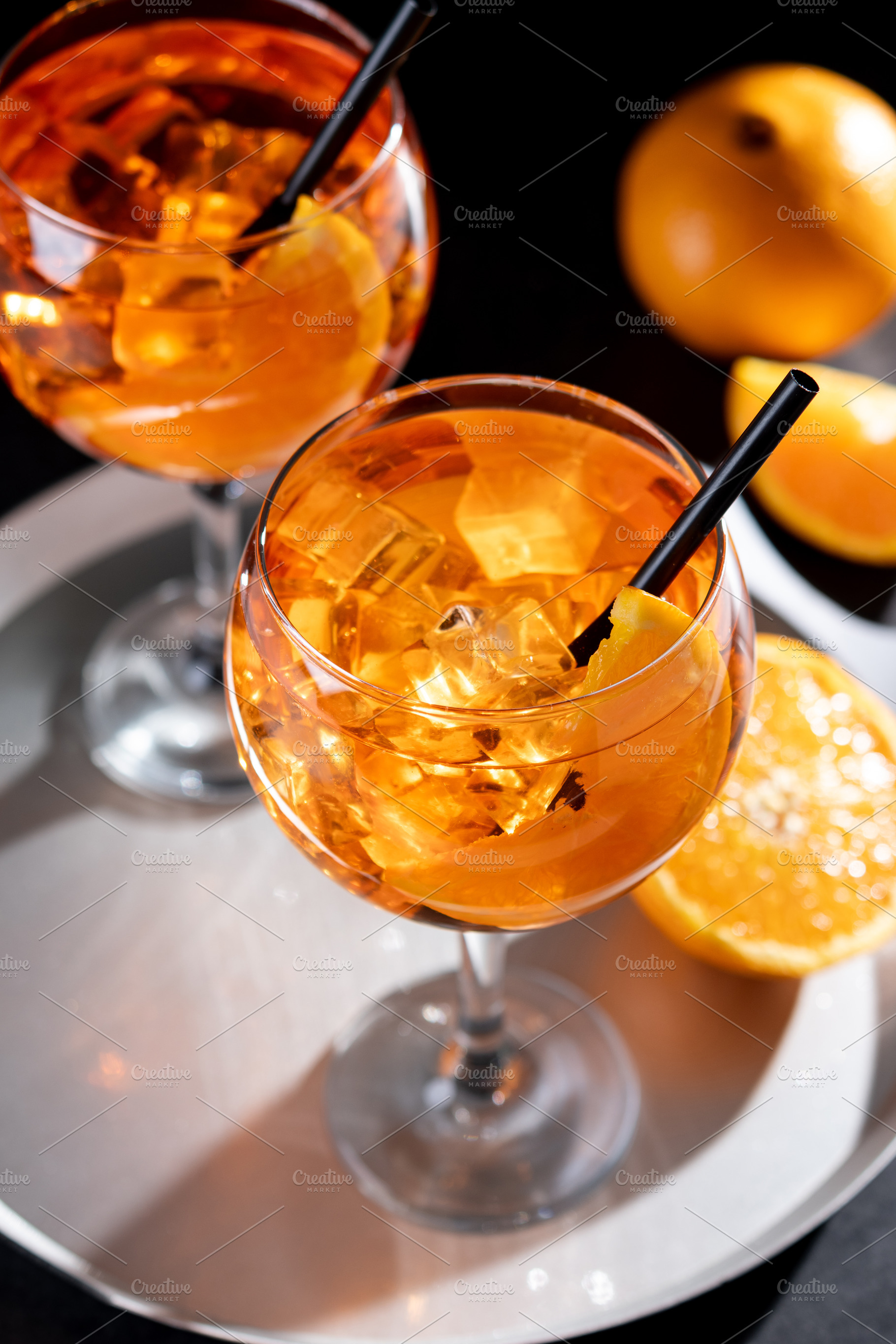 Refreshing Aperol Spritz cocktails with orange slices and ice in elegant glasse, a Food & Drink Photo by etorres69