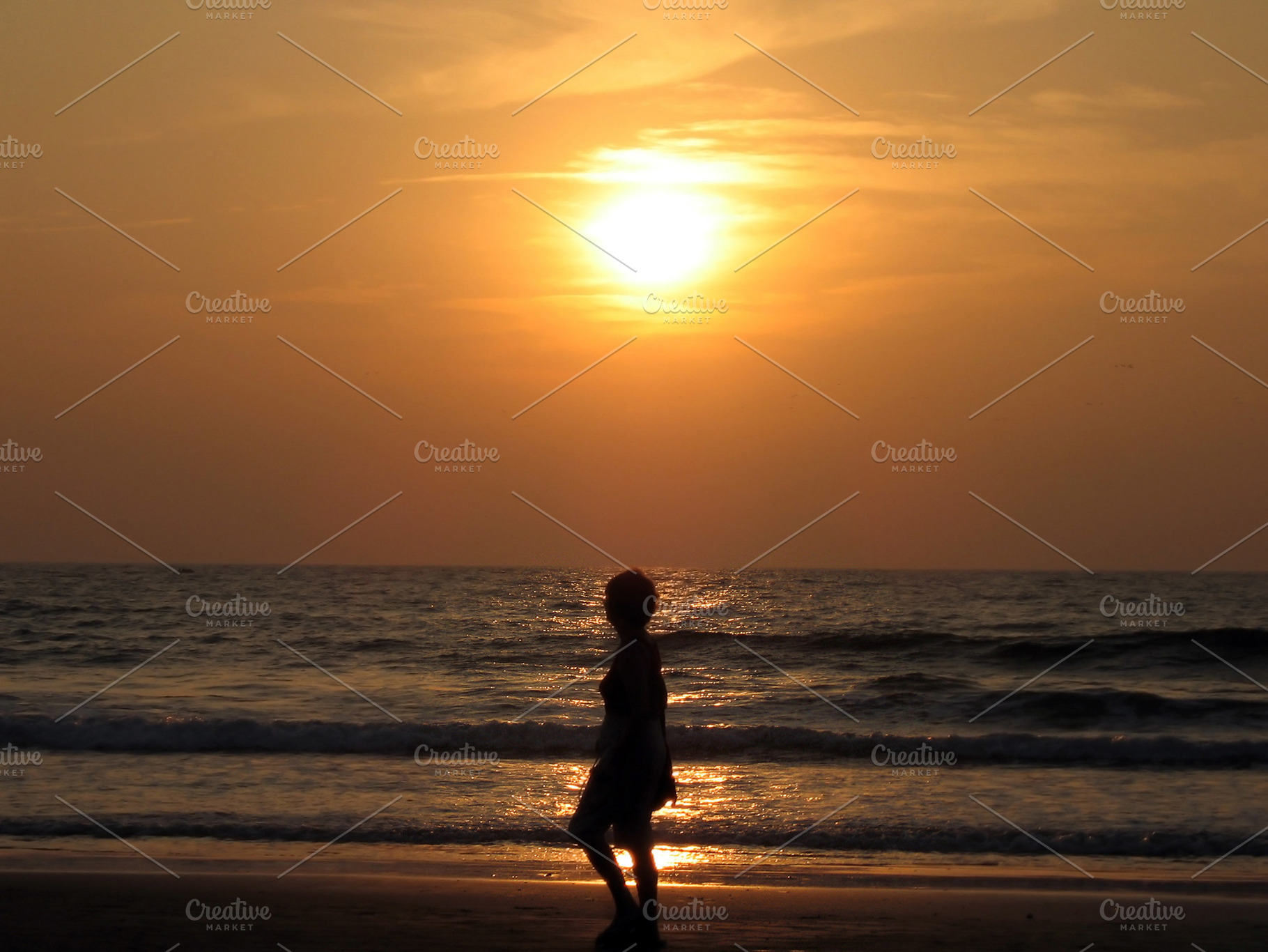 Woman silhouette at sunset beach, a Photo by saiko3p
