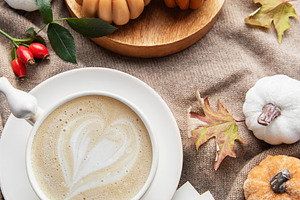 Autumn hygge flat lay with coffee and pumpkin candles