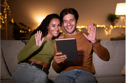 Spouses Waving To Digital Tablet, a Person Photo by Prostock-Studio
