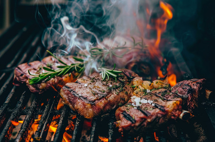 Two steaks grilling on open flames,, a Photo by Iftikhar Alam