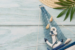Seashells, sunglasses, straw hat, starfish and decorative sailbo, a Holiday Photo by Olena Rudo