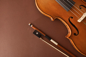 Traditional stringed violin and bow placed diagonally on brown b, an Arts & Entertainment Photo by Davizro's Market