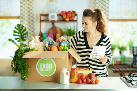 happy modern housewife with food box in kitchen, a Person Photo by Alliance Images