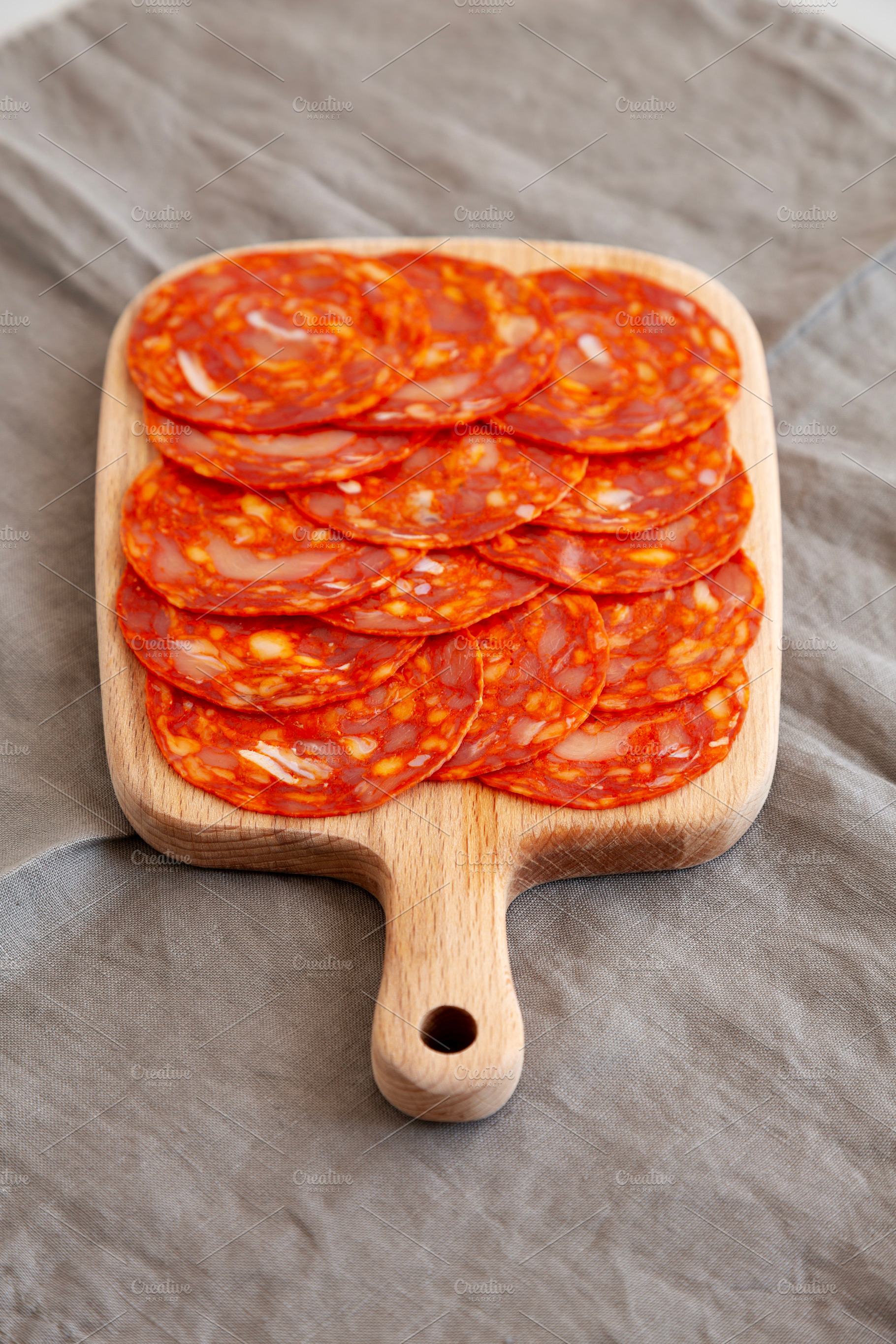 Cold Meat Chorizo Slices on a Wooden Board, side view., a Food & Drink Photo by LiudmylaChuhunova