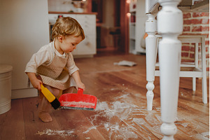 Little girl cleaning up flour mess, a Holiday Photo by HalfPoint