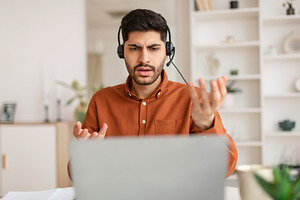 Arab man having video call using laptop and talking, a Photo by Prostock-Studio